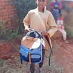 élève recevant un cartable scolaire